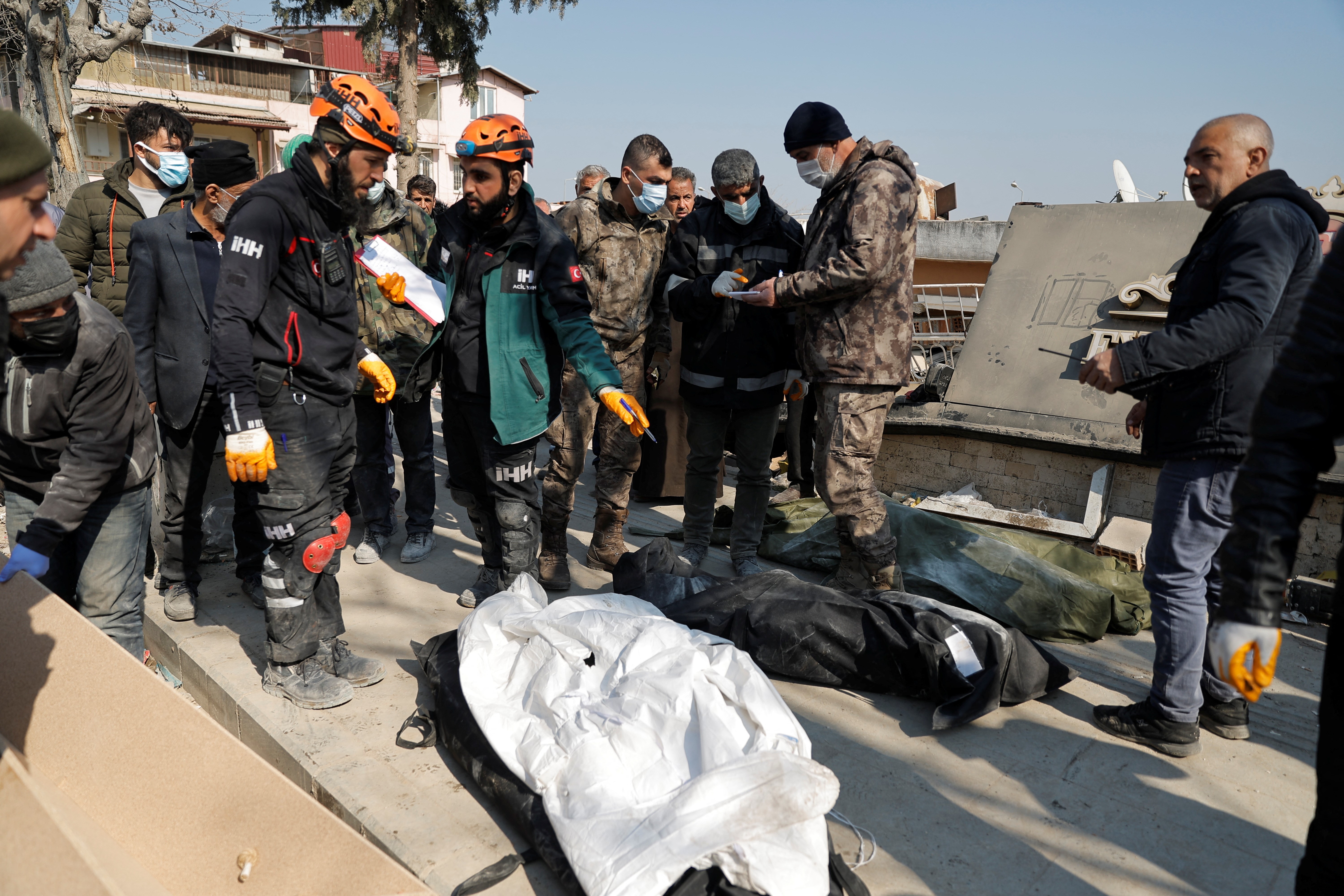 Authorities and rescue workers stand next to covered bodies of victims, in the aftermath of the deadly earthquake, in Antakya, Turkey February 18, 2023. Photo: Reuters