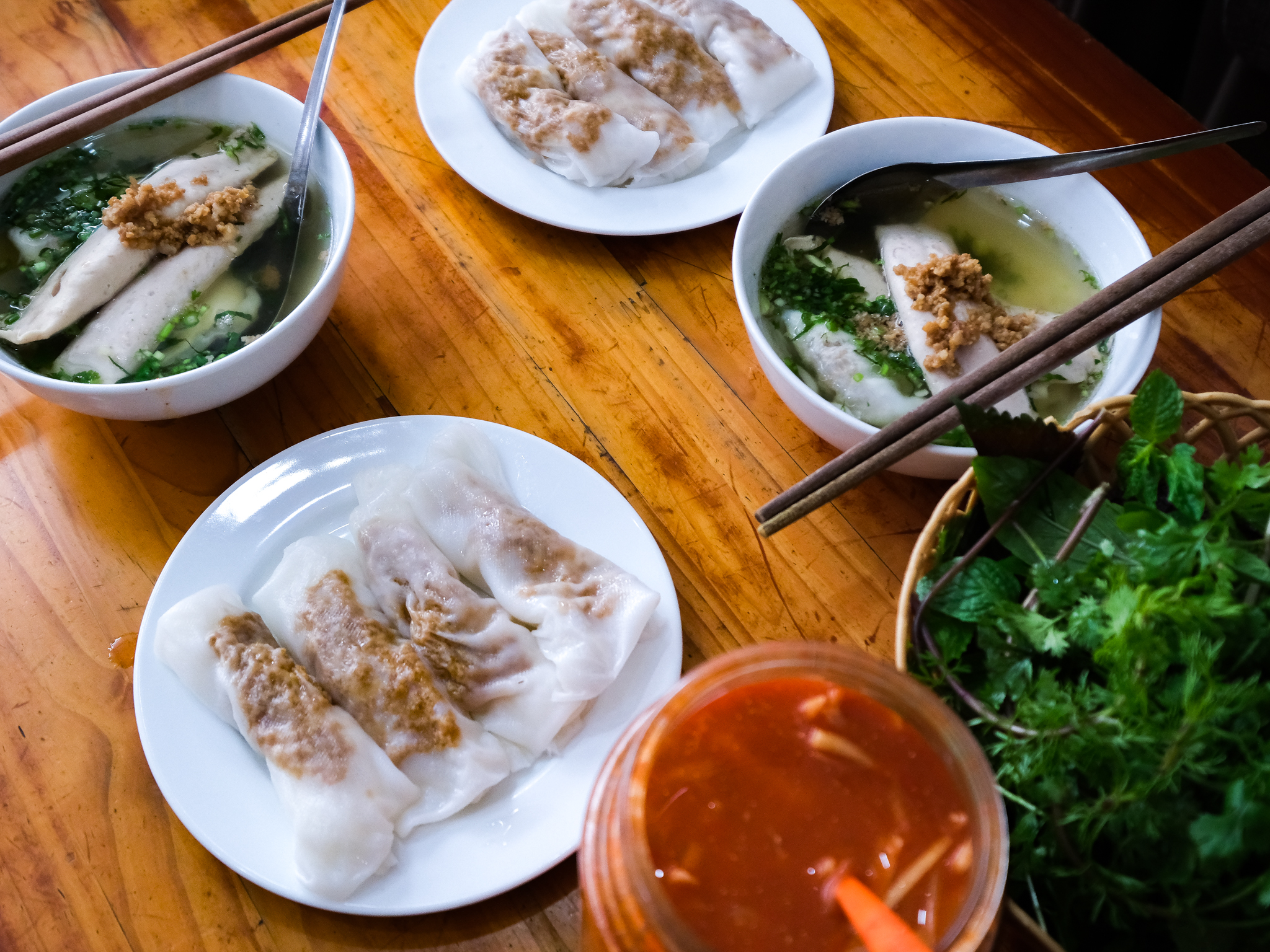 Rolls of banh cuon are served with bowls of hot broth at Banh Cuon Cao Bang stall in Hanoi, Vietnam. Photo: Nam Tran / Tuoi Tre News