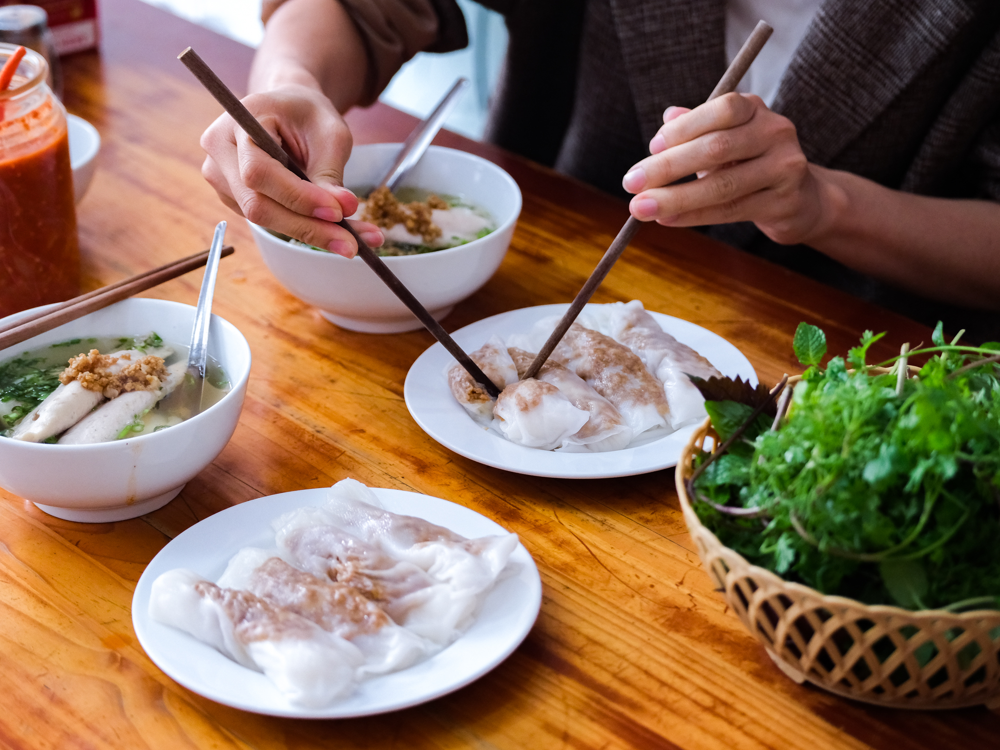 A diner uses chopsticks to cut a roll of banh cuon. Photo: Nam Tran / Tuoi Tre