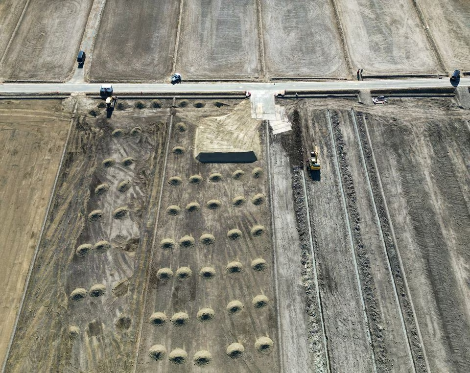Diggers work in a field where contaminated soil from the fallout of the Fukushima nuclear plant was kept and which is now in the works to be converted back to a rice field, next to Jinichi Abe's rice field, in Namie, about 7 km from the crippled Fukushima Dai-Ichi nuclear plant, Fukushima Prefecture, Japan February 28, 2023. Photo: Reuters