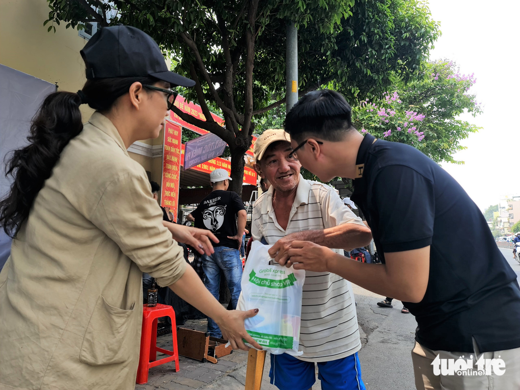 A local man receives a gift from the organizer after getting a new haircut. Photo: Cong Trieu / Tuoi Tre