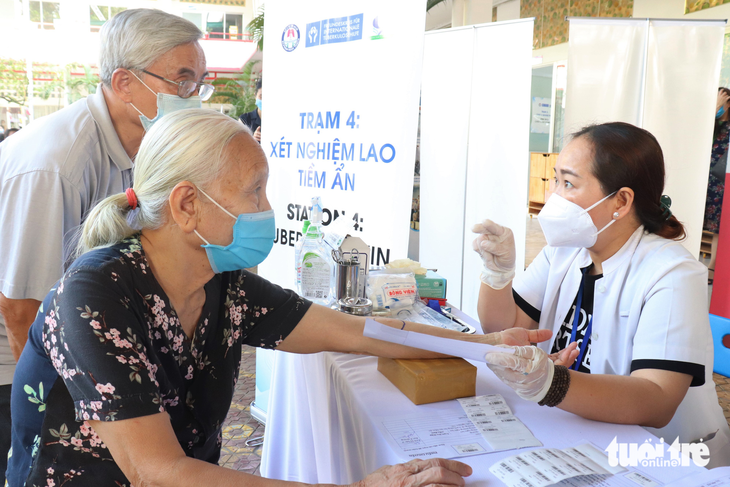 A local healthcare worker tells Nguyen Thi Lang, an 82-year-old resident in District 5, Ho Chi Minh City, and her husband how to take care of her skin after a latent TB skin test. Photo: Xuan Mai / Tuoi Tre