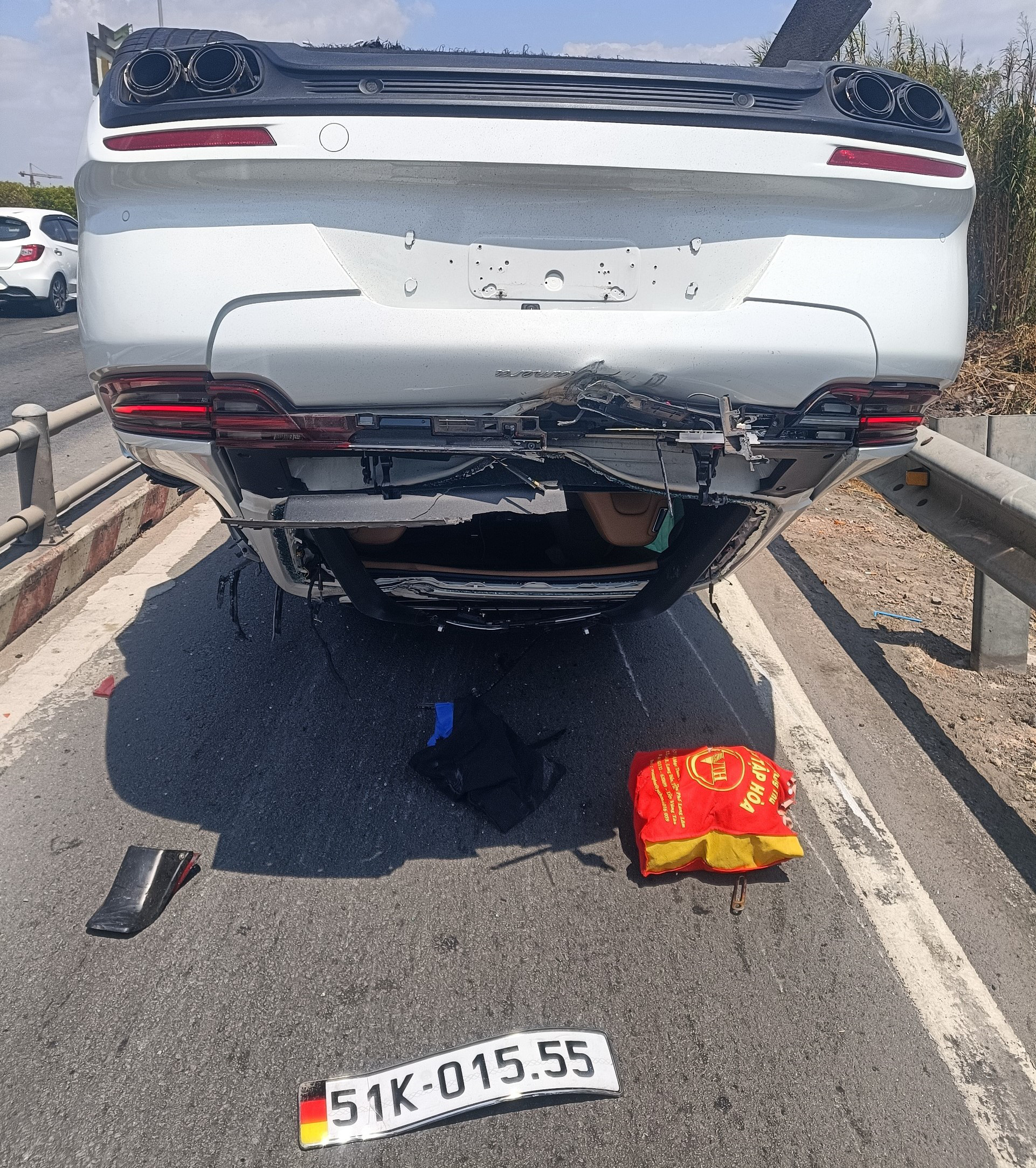 A Porsche lies upside down after crashing into several motorbikes and overturning on the connected road of the Ho Chi Minh City-Long Thanh-Dau Giay Expressway in Thu Duc City, Ho Chi Minh City, March 19, 2023. Photo: Minh Hoa / Tuoi Tre
