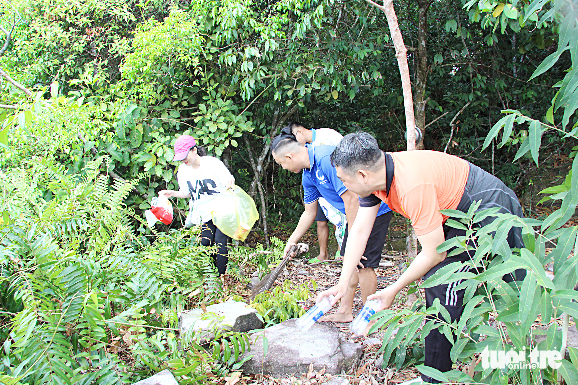 Young volunteers collect trash littered by tourists at the peak of Tien Son Mountain, which is a popular destination to take photos
