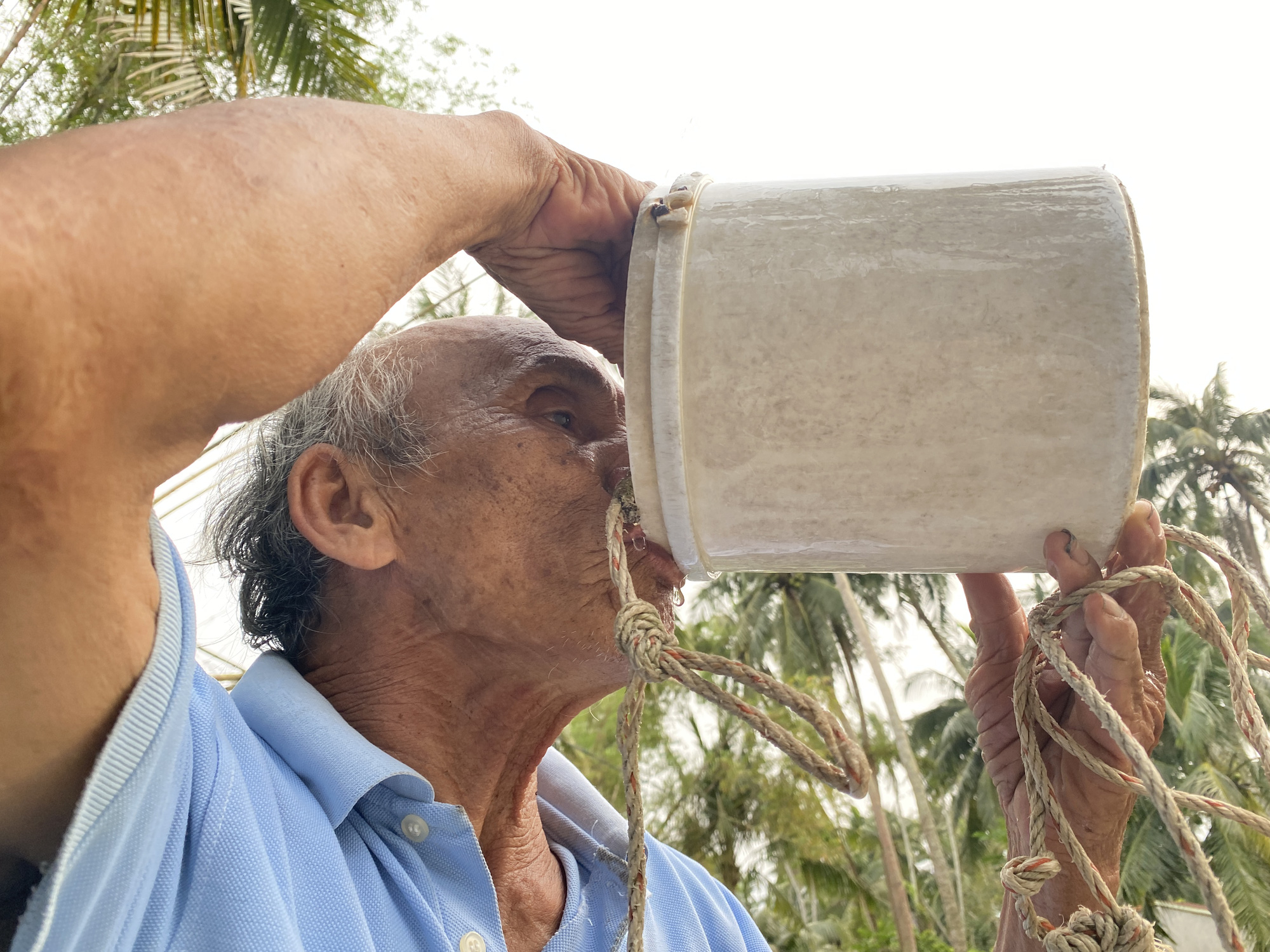 A man drinks water straight from an ancient well in Tam Hai Island Commune, off Nui Thanh District in Quang Nam Province, central Vietnam. Photo: B.D. / Tuoi Tre