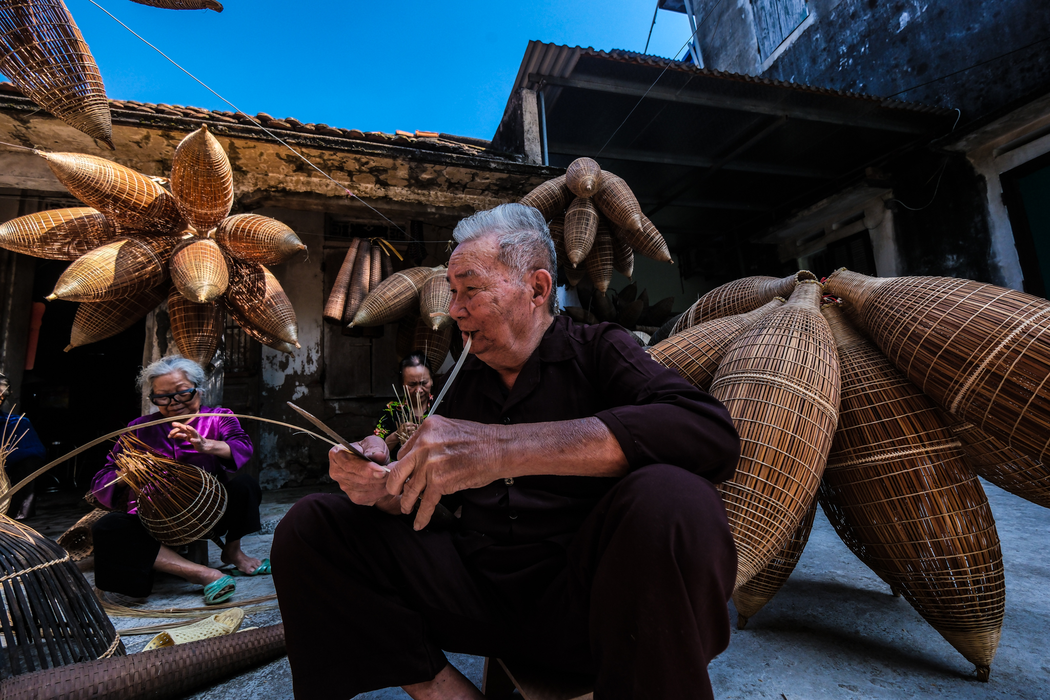 A man is shredding bamboo into strings before weaving them into đó and rọ. Photo: Nam Tran / Tuoi Tre News