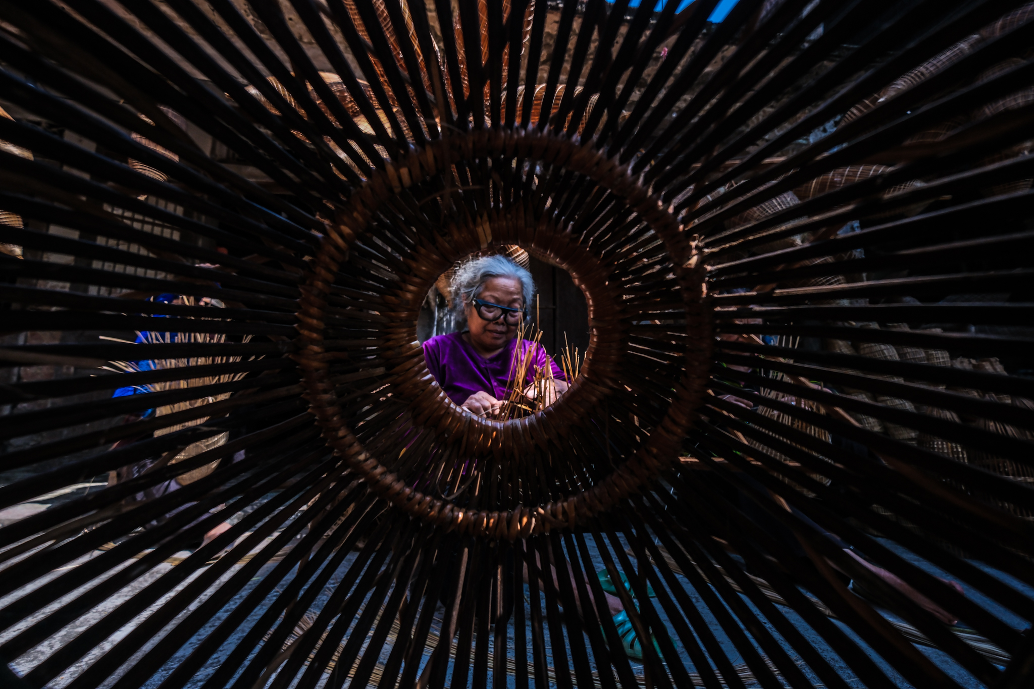 An elderly woman is seen making bamboo fishing traps at Thu Sy craft village in Thu Sy Commune, Hung Yen Province, Vietnam. Photo: Nam Tran / Tuoi Tre News