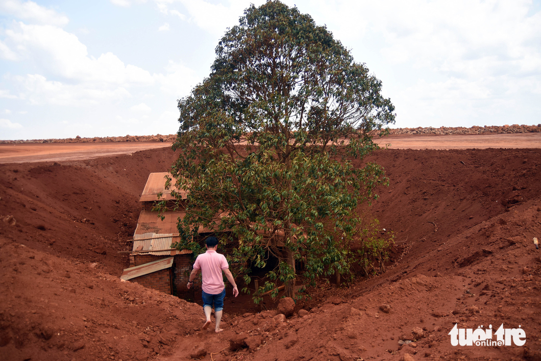 A photo shows of Ngo Quang Hanh’s house that seems to lie in a hole