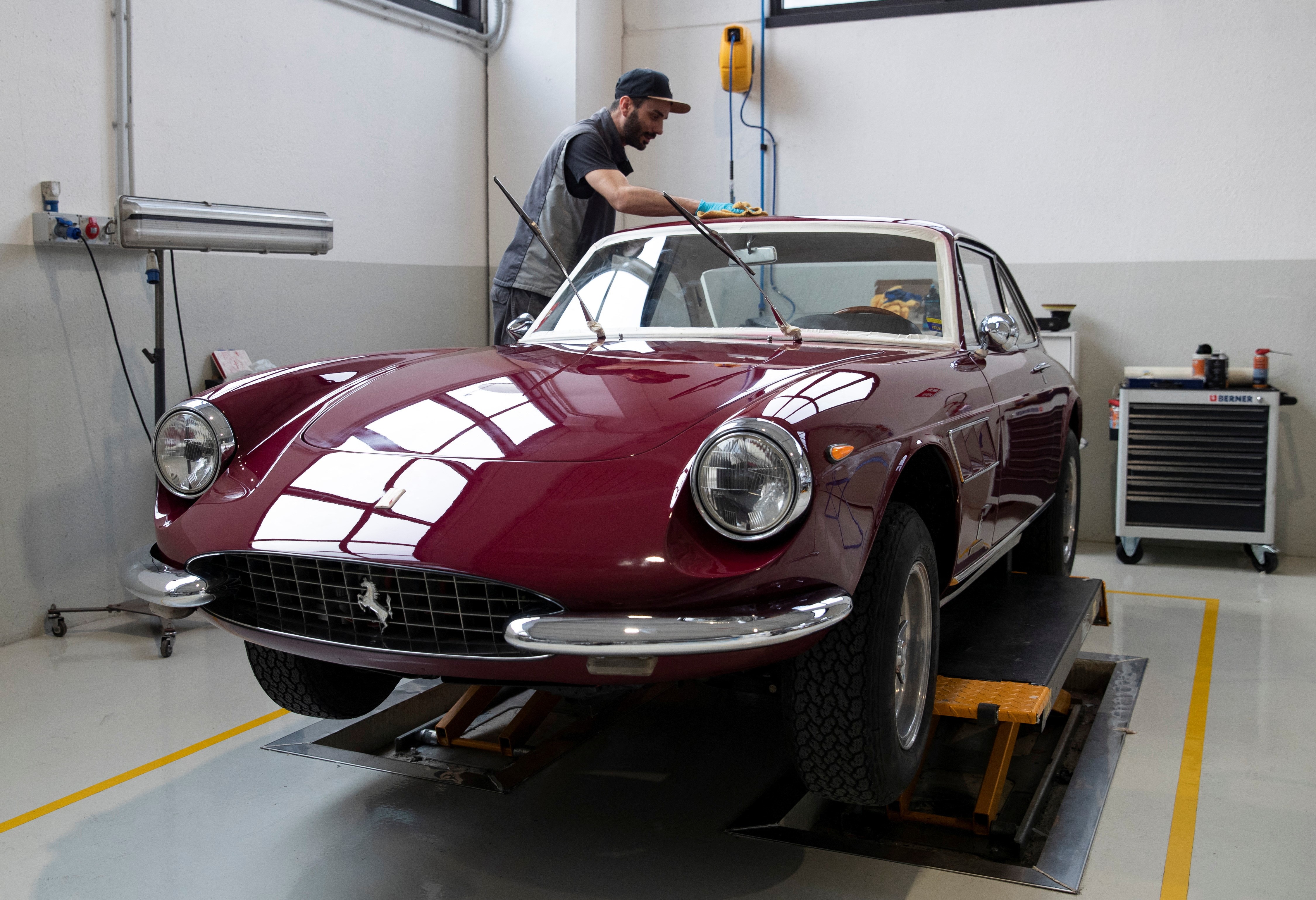 A man works on a Ferrari Classiche car at the Atelier Fiorano, a Rossocorsa authorised bodyshop in Assago near Milan, Italy, April 6, 2023. Photo: Reuters