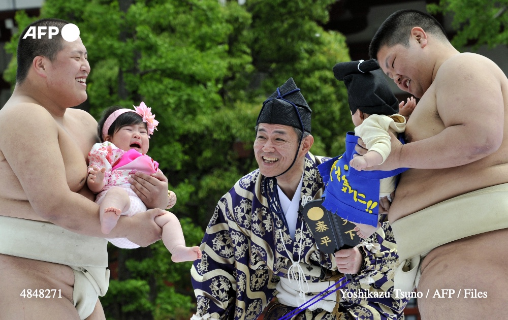 Student sumo wrestlers carry crying babies during the 'Baby-cry Sumo' competition at Tokyo's Sensoji temple on April 30, 2011. Photo: AFP