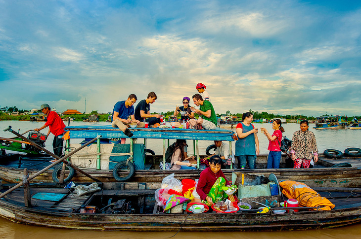 Tourists visit and enjoy food at Long Xuyen floating market. Photo: An Giang Department of Culture, Sports and Tourism