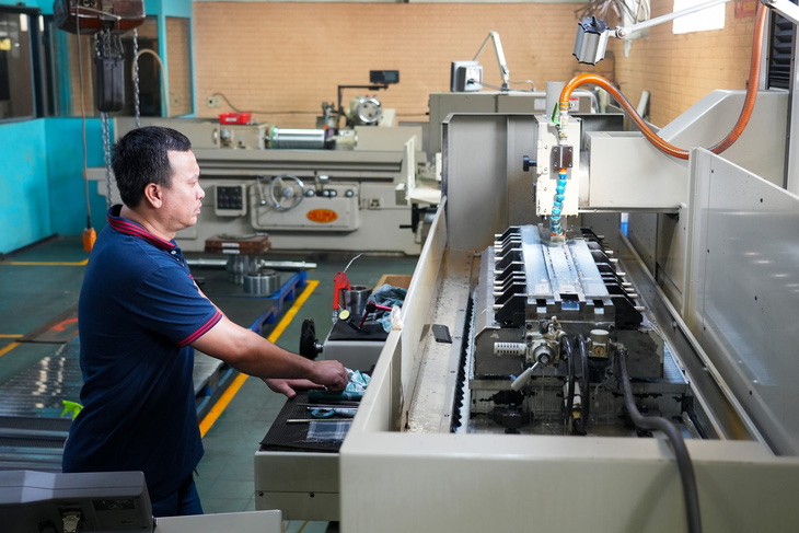 An employee at work in a production facility. Photo: Huu Hanh / Tuoi Tre