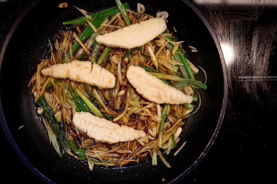 A dish containing pieces of 3D-printed cultivated grouper fish is prepared for a tasting at the offices of Steakholder Foods in Rehovot, Israel, April 23, 2023. Photo: Reuters