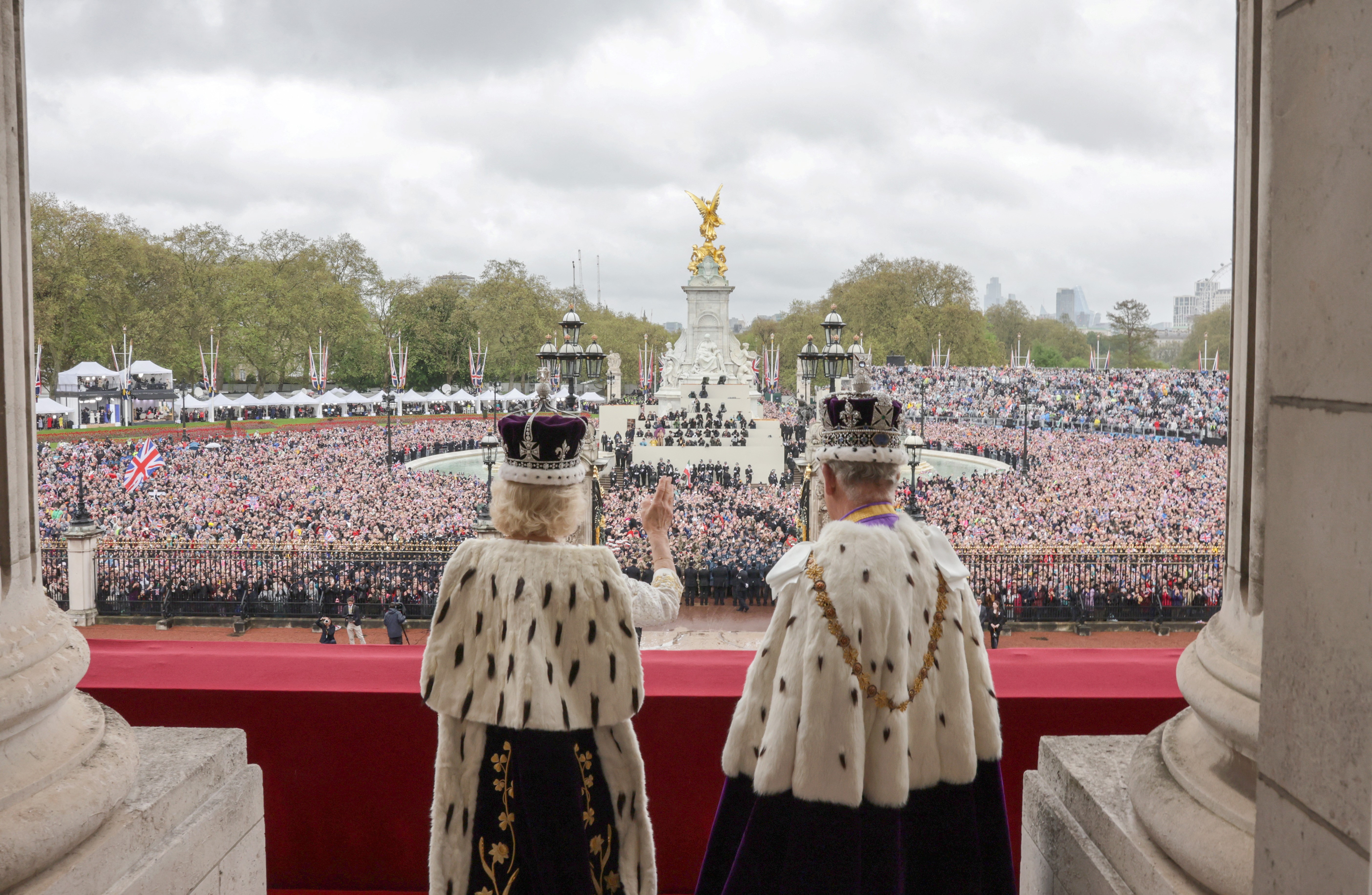 In This handout image released by Buckingham Palace, King Charles III and Queen Camilla wave from the balcony of Buckingham Palace after their Coronation on May 06, 2023 in London, England. Photo: Reuters