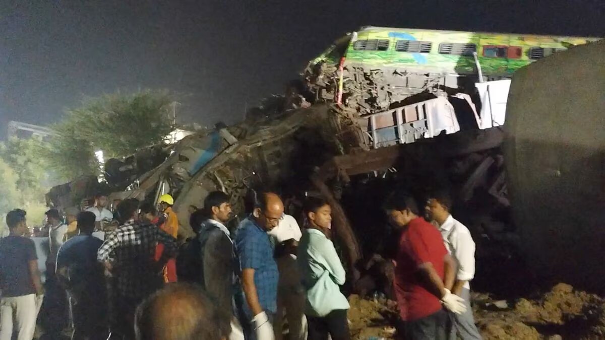Onlookers and rescue workers stand next to damaged coaches, after trains collided in Balasore, India June 3, 2023, in this picture obtained from social media. Photo: Reuters