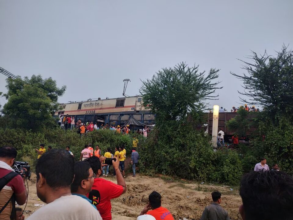 Onlookers and rescue workers stand next to damaged coaches, after trains collided in Balasore, India June 3, 2023, in this picture obtained from social media. Photo: Reuters