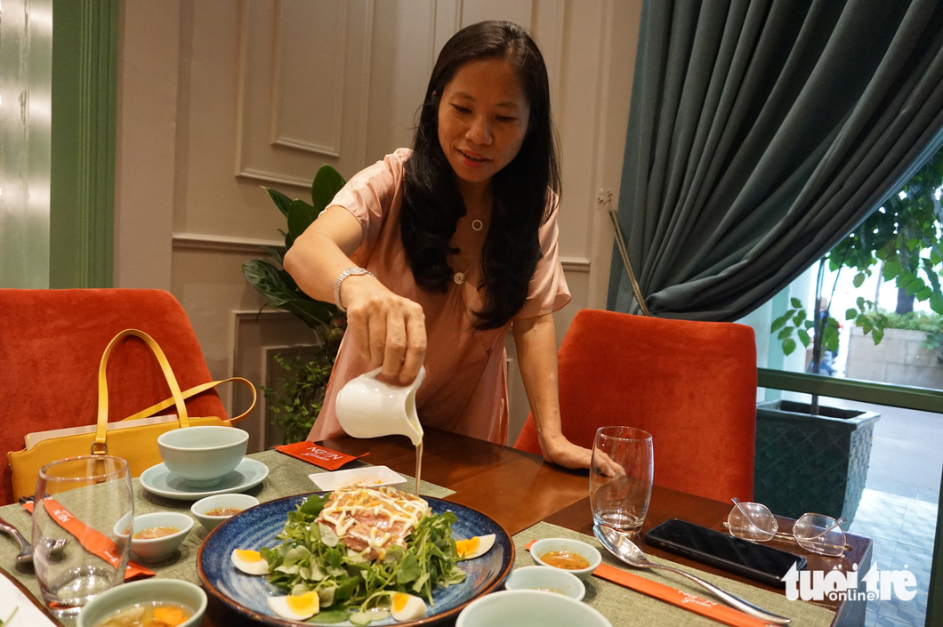 Hanh showcases the pepper elder salad with passion fruit sauce at Ngon Garden. Photo: T. Dieu / Tuoi Tre