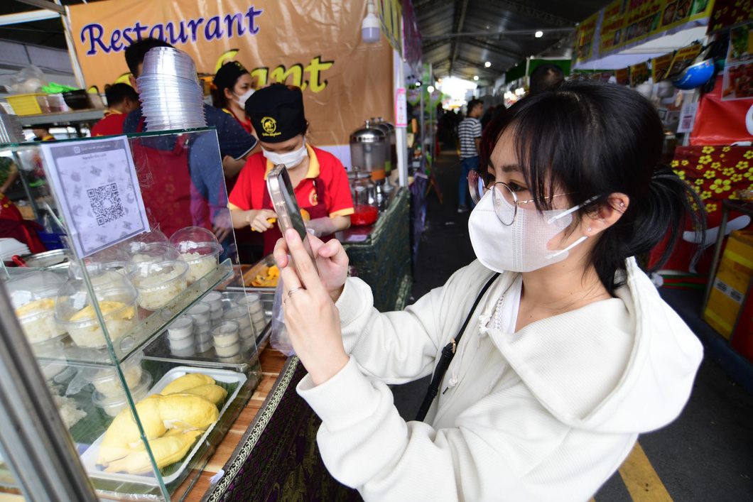A young woman visits the Cashless Town Festival on June 15, one day before the official opening of the event. Photo: Quang Dinh / Tuoi Tre