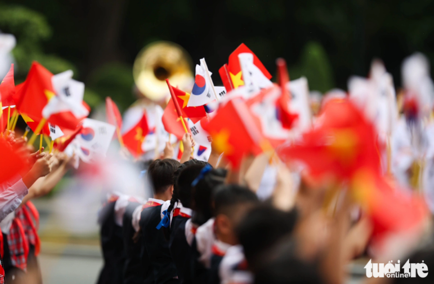 Children wave the flags of Vietnam and South Korea to welcome the leader of the Eastern Asian nation. Photo: Nguyen Khanh / Tuoi Tre