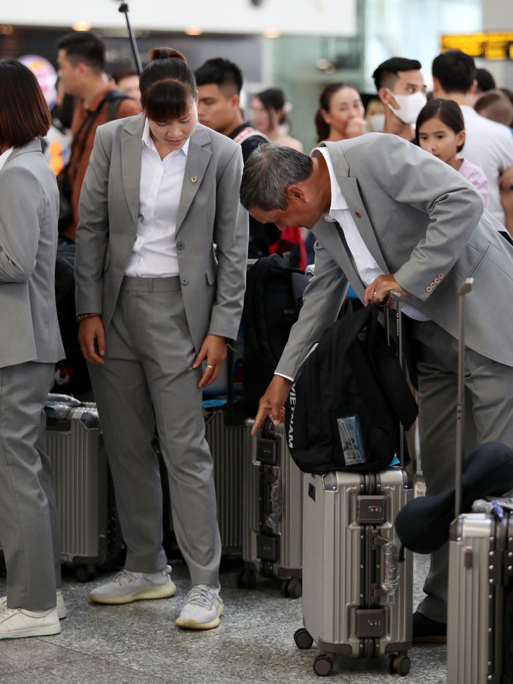 Head coach Mai Duc Chung (R) interacts with goalkeeper Khong Thi Hang at Noi Bai International Airport in Hanoi before their departure for New Zealand, July 5, 2023. Photo: Le Duc / Tuoi Tre