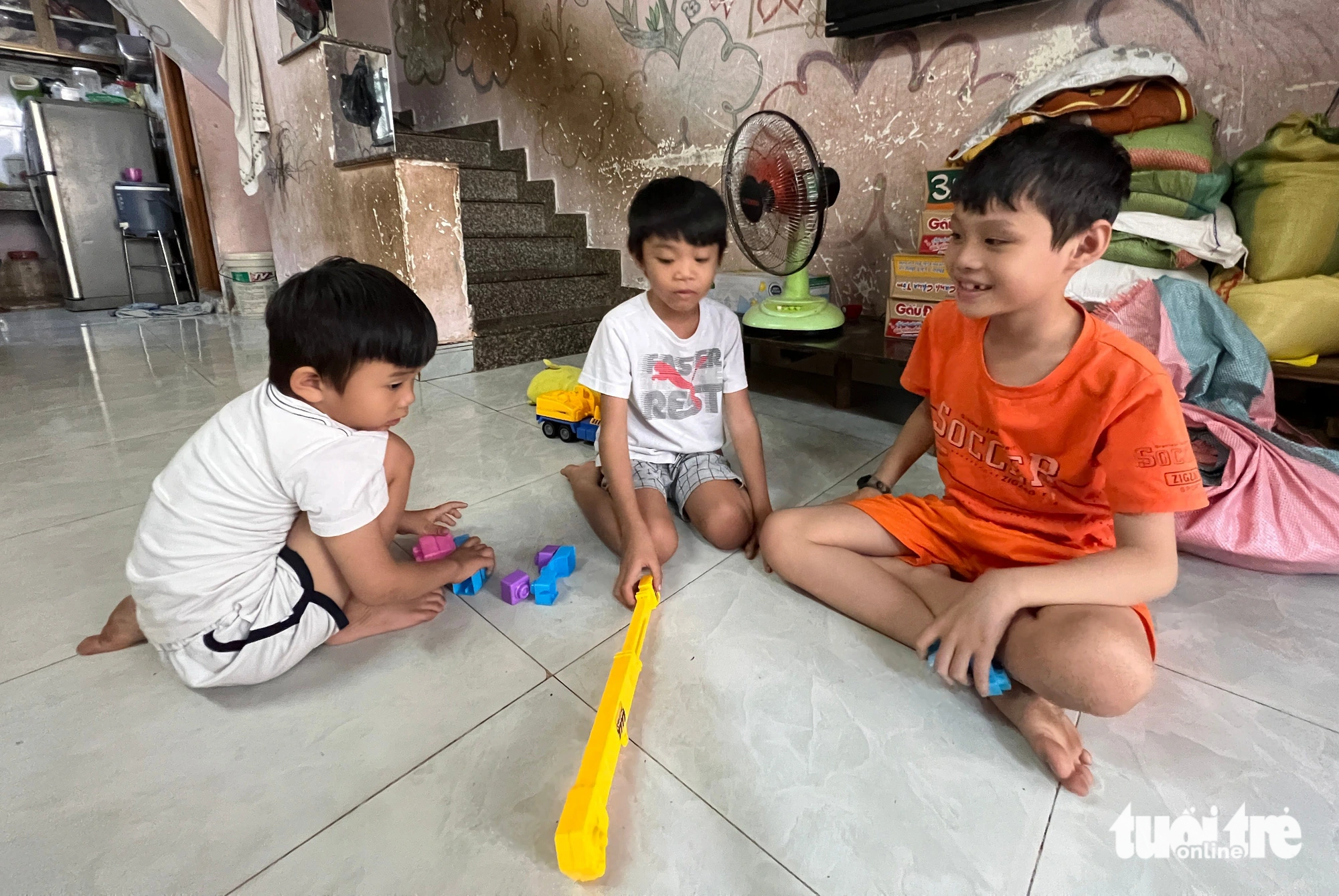 Vinh (R), Minh (C), and Quang play toy blocks in their house. Photo: Yen Trinh / Tuoi Tre