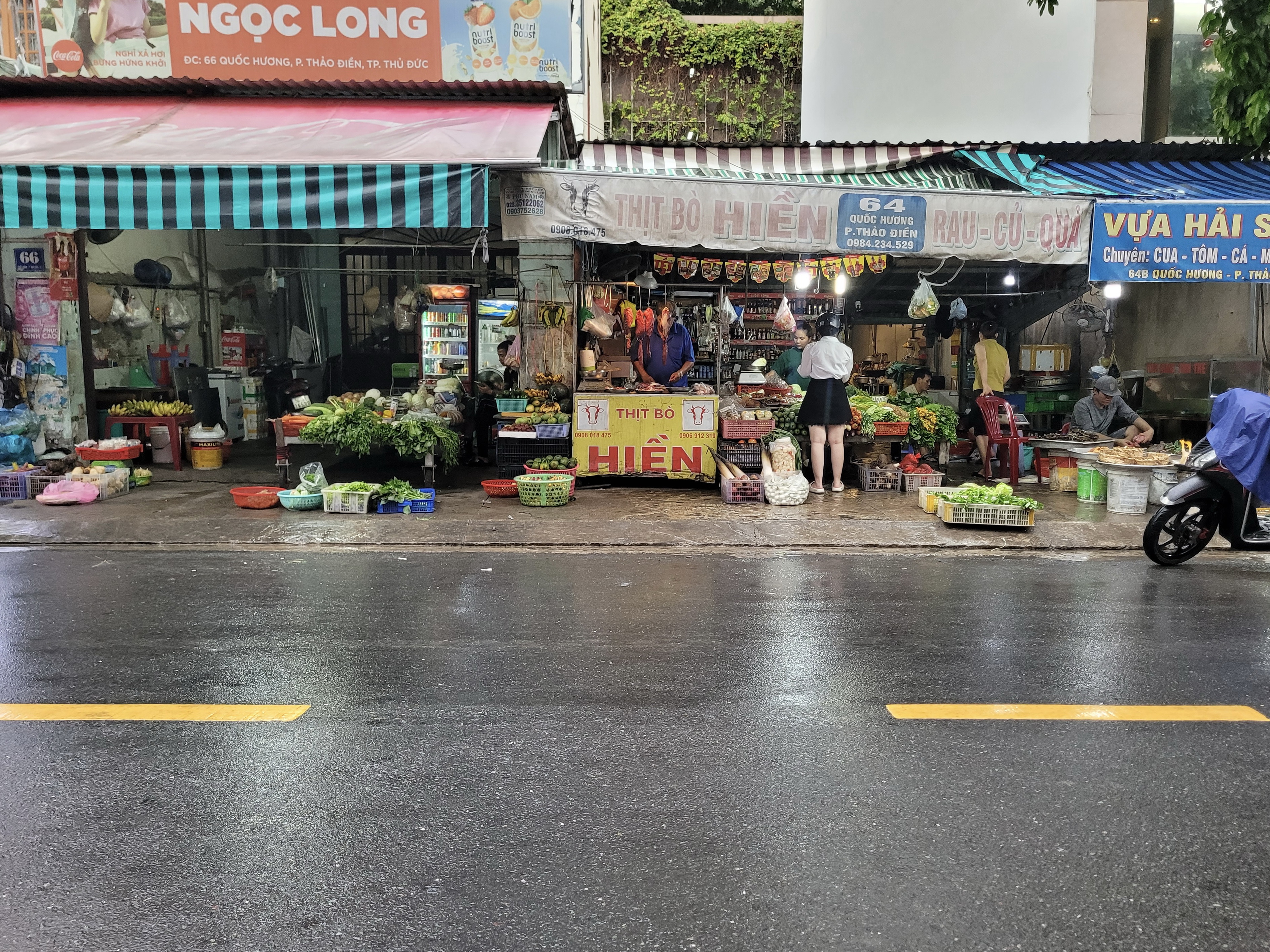 A woman buy groceries at a shop on the street of Thao Dien Ward, Ho Chi Minh City. Photo: Ray Kuschert / Tuoi Tre News