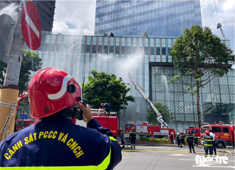 The head of the firefighting force at Saigon Centre in
District 1, Ho Chi Minh City regulate the fire fighting through a walkie-talkie.