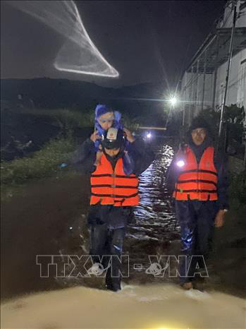 Two rescuers evacuate a child to a safer place in Lam Dong Province, located in Vietnam’s Central Highlands region. Photo: Vietnam News Agency