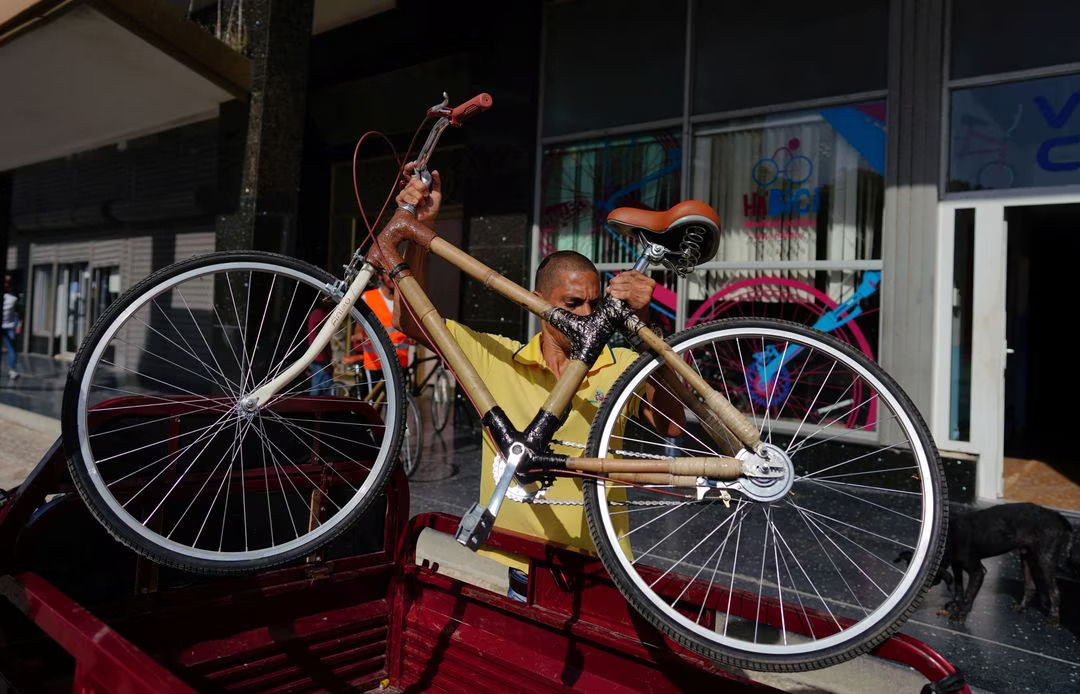 An employee of Velo Cuba unloads from a tricycle an eco-friendly bamboo bicycles in Havana, Cuba, July 21, 2023. Photo: Reuters