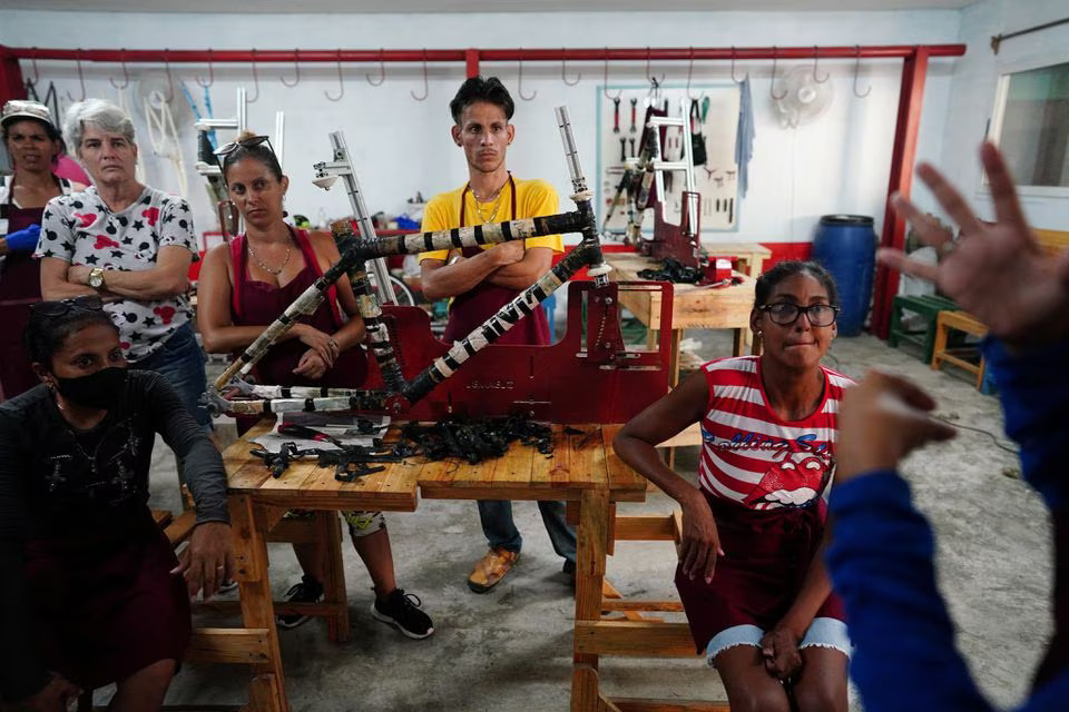 A group of partial hearing students communicate using sign language during a workshop to produce eco-friendly bamboo bicycles in Havana, Cuba, July 5, 2023. Photo: Reuters
