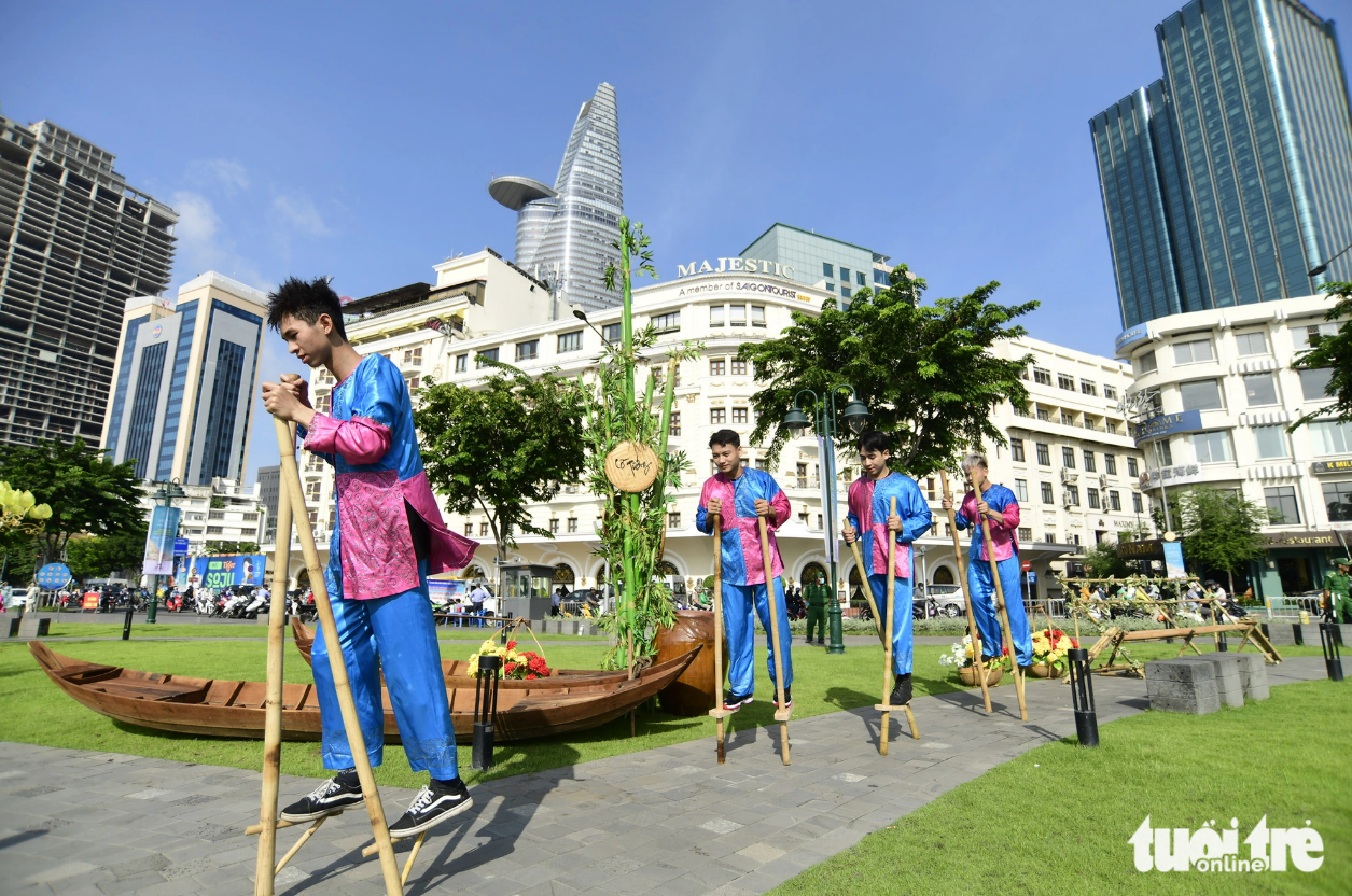 Men walk on stilts along the Saigon River. Photo: Quang Dinh / Tuoi Tre