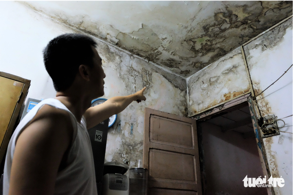 Nam, a resident at the apartment building, points at a corner of his deteriorated apartment. Photo: Phuong Nhi / Tuoi Tre