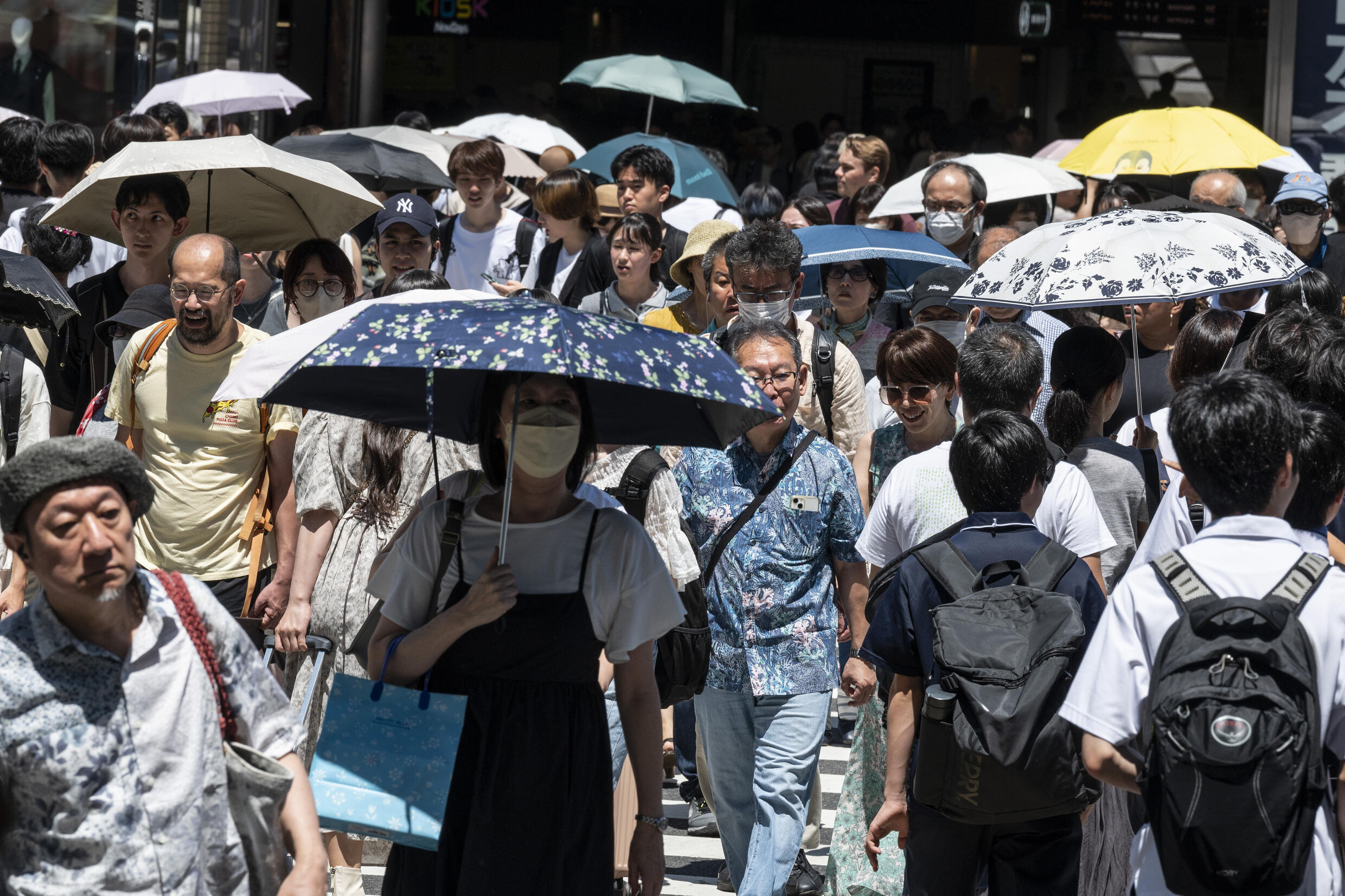 This photo taken on July 30, 2023 shows people using umbrellas and parasols to seek relief from the heat while walking outside Shinjuku station, as temperatures of 35C-plus (95F) have scorched the Japanese capital Tokyo for weeks. Photo: AFP