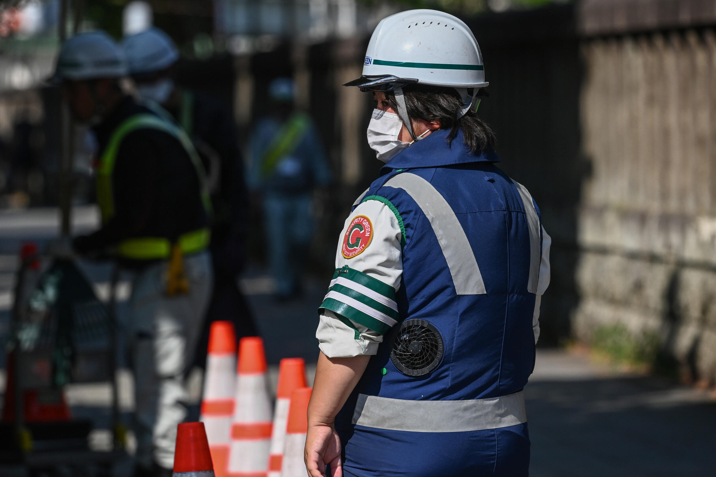 This photo taken on August 4, 2023 shows a municipal worker wearing a jacket with battery-powered built-in fans to keep cool in the heat while working on a street in Tokyo. Photo: AFP