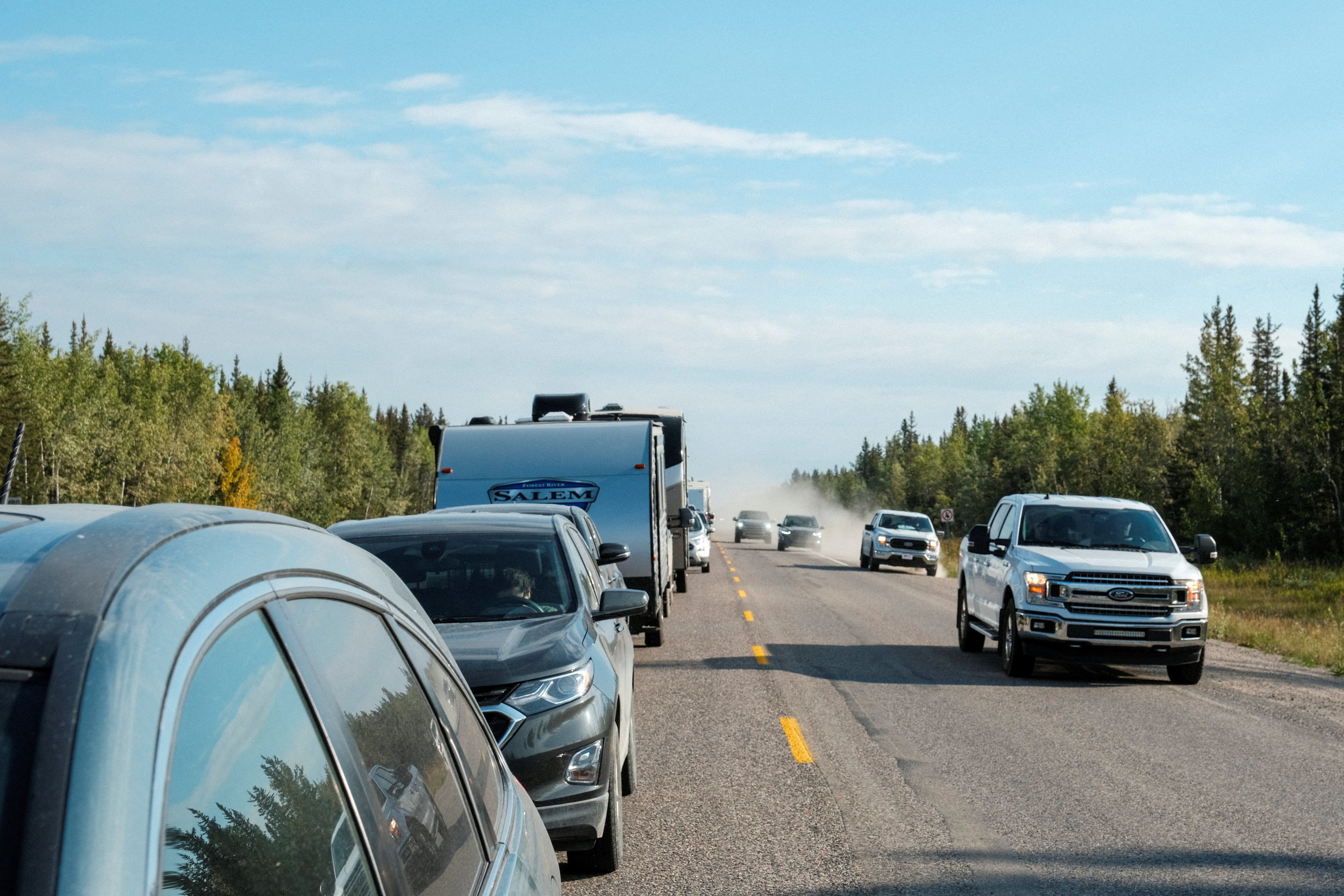 Cars pass a line of vehicles waiting for fuel, after an evacuation order was declared due to the proximity of a wildfire in Yellowknife, in Fort Providence, Northwest Territories, Canada August 17, 2023. Photo: Reuters