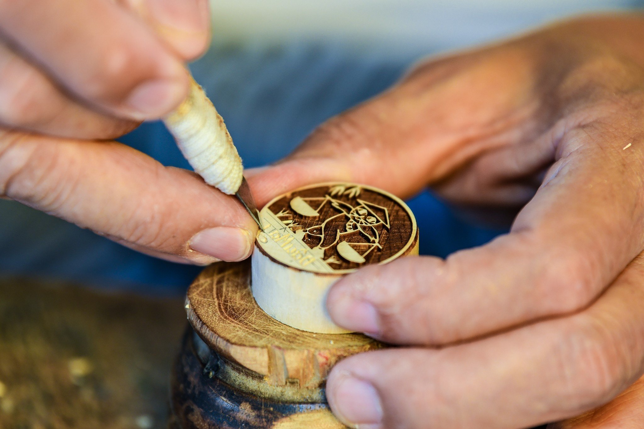 Pham Ngoc Toan, 68, engraves a wooden stamp at his stall on Hang Quat Street, Hoan Kiem District, Hanoi. Photo: Nam Tran / Tuoi Tre News