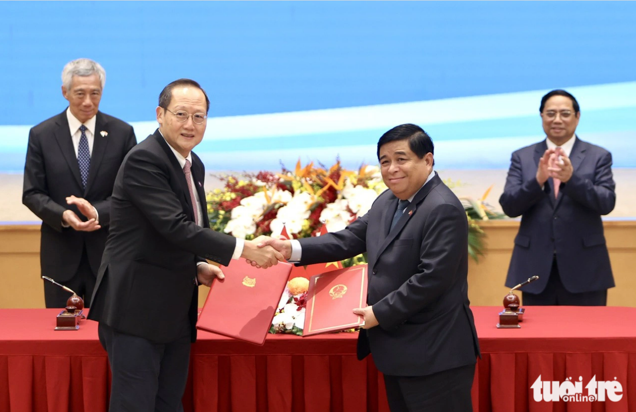 Minister of Planning and Investment Nguyen Chi Dung (R) shakes hands with Singaporean Minister for Manpower and Second Minister for Trade and Industry Tan See Leng. Photo: Nguyen Khanh / Tuoi Tre