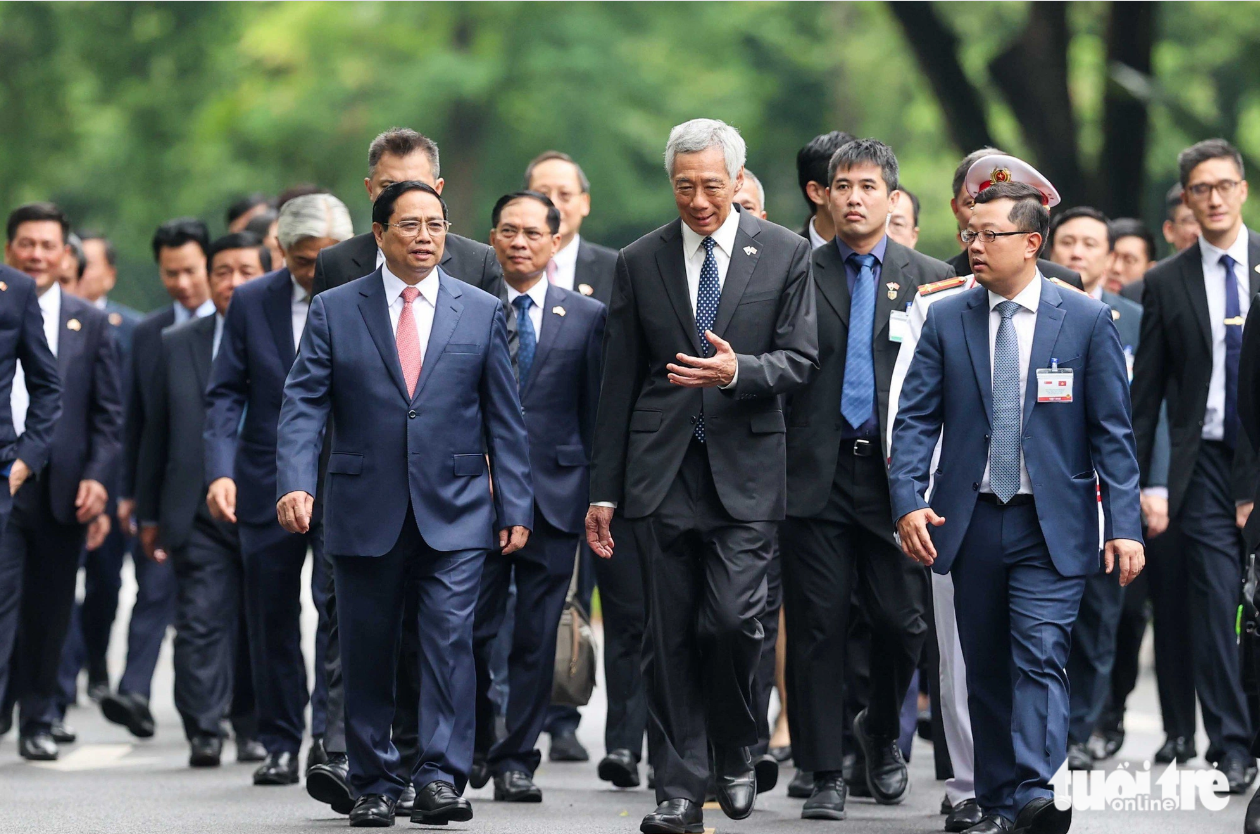 The two prime ministers of Vietnam and Singapore, and other officials walk to the headquarters of the Government Office for talks. Photo: Nguyen Khanh / Tuoi Tre