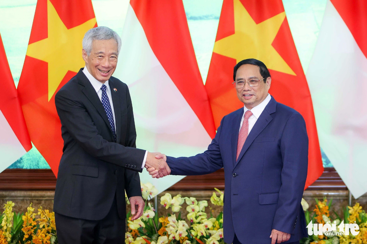 Prime Minister Pham Minh Chinh (R) shakes hands with his Singaporean counterpart Lee Hsien Loong. Photo: Nguyen Khanh / Tuoi Tre