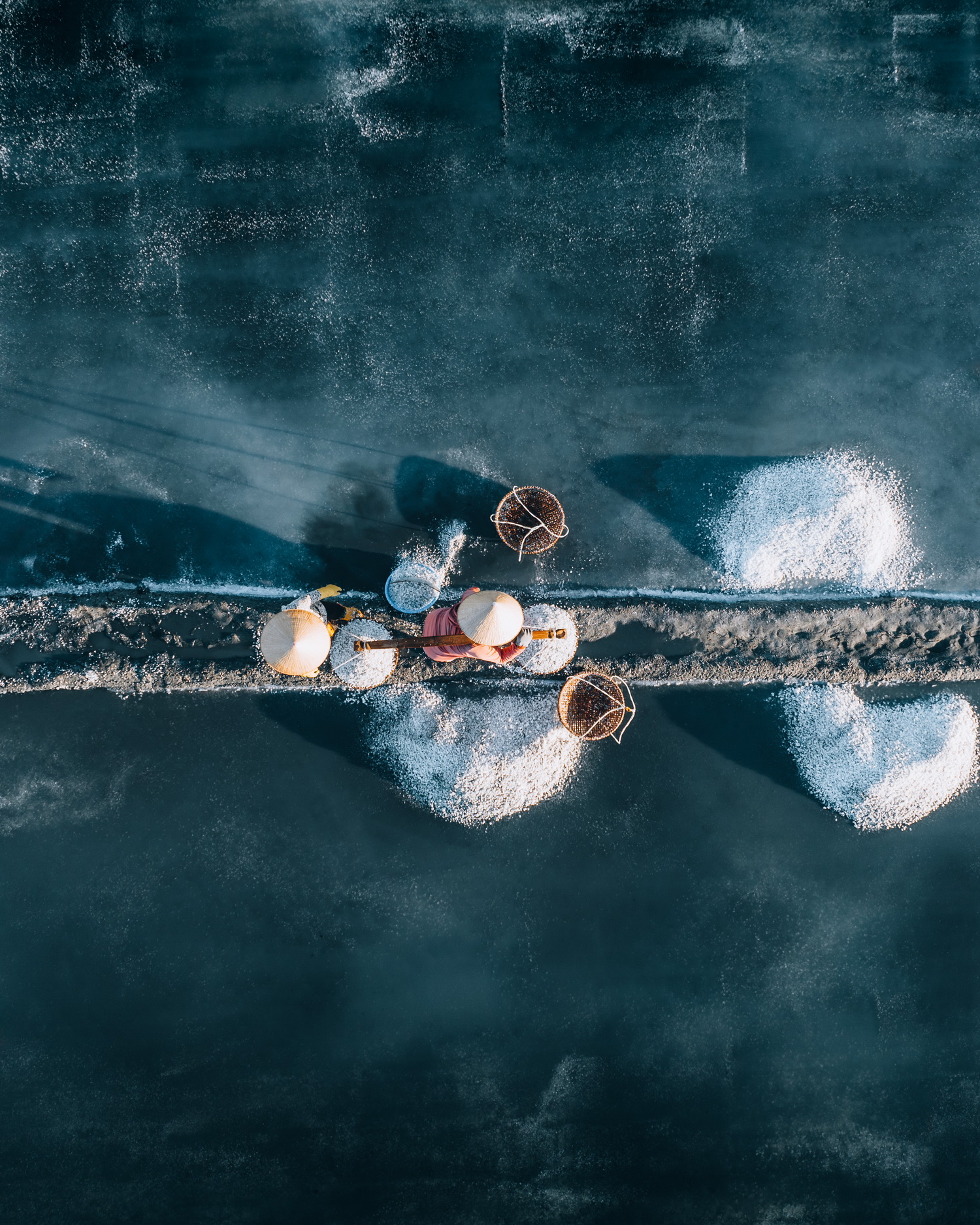 A bird's-eye view taken by Benjamin Tortorelli of farmers working on a salt field in Tuyet Diem salt village, Phu Yen Province, central Vietnam.