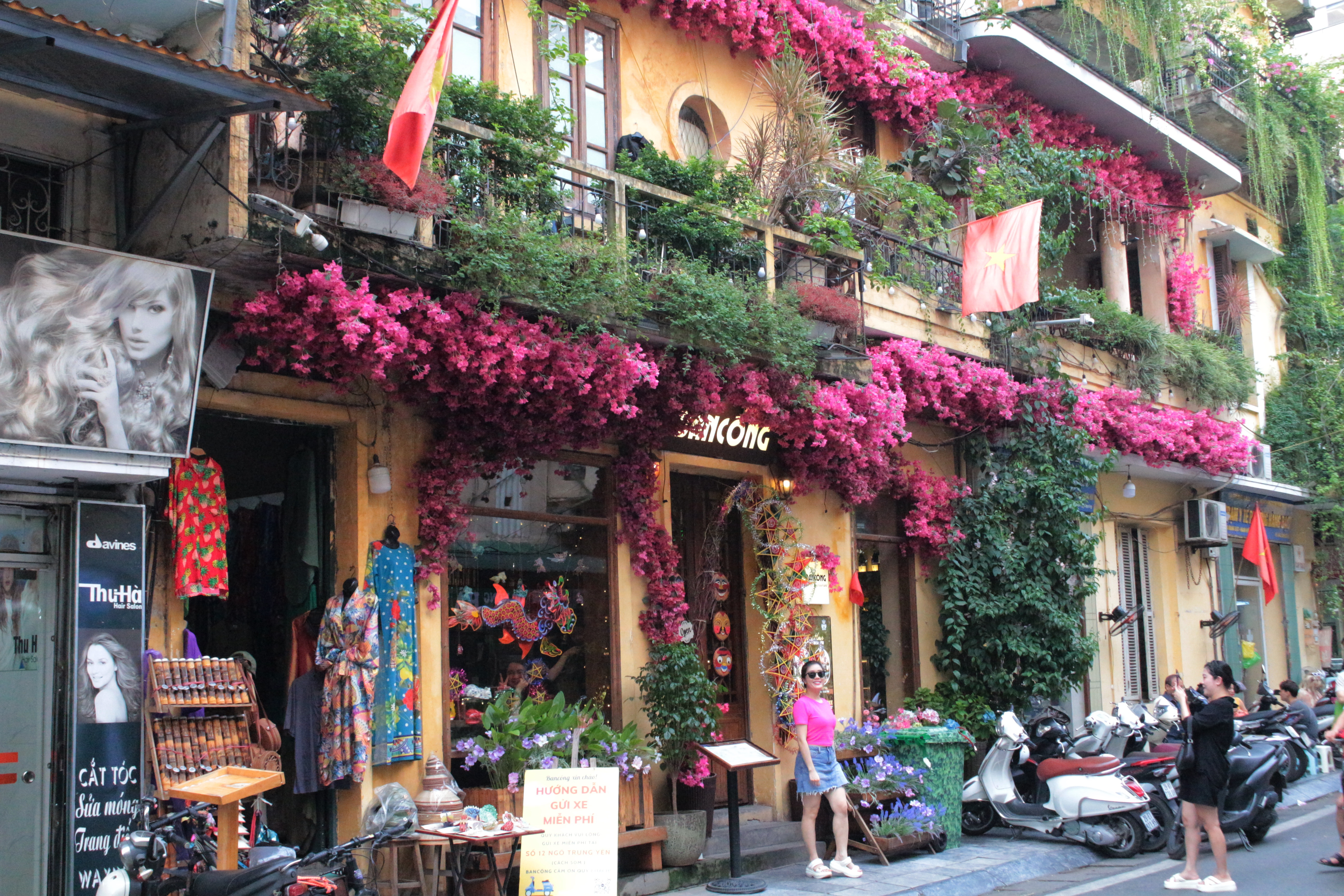 A visitor is taking photo in front of a coffee shop in Hanoi, Vietnam. Photo: Ray Kuschert / Tuoi Tre News
