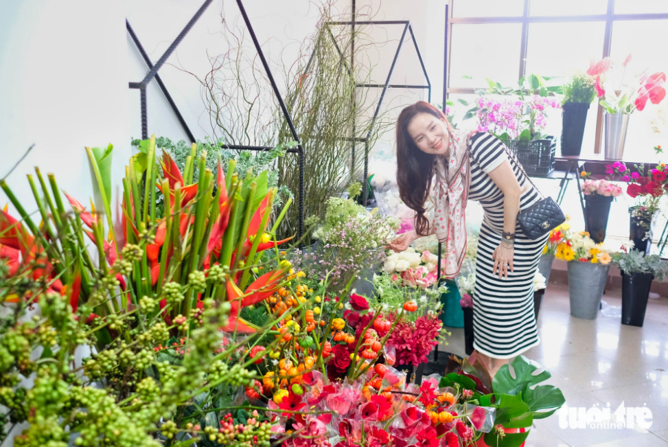 A visitor poses for a photo in a flower display area during the 37th World Flower Council Summit in Da Lat City. Photo: Mai Vinh / Tuoi Tre