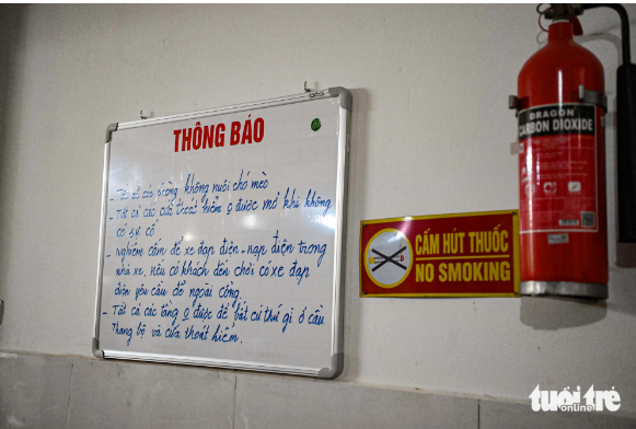 The building owner writes fire prevention and fighting regulations and how to use the escape ladder on a board on the ground floor. Photo: Hong Quang / Tuoi Tre