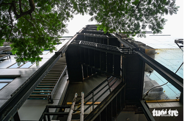 The owner of this building hangs air conditioners’ condenser units on an escape ladder. Photo: Hong Quang / Tuoi Tre