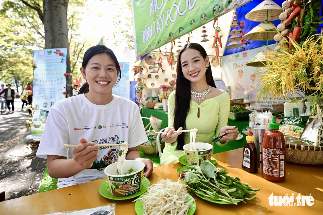 Vietnam Pho Festival 2023's ambassadors Miss Intercontinental 2022 Le Nguyen Bao Ngoc (left) and Vietnam's top swimmer Nguyen Thi Anh Vien enjoy pho at the festival at Yoyogi Park, Tokyo, Japan on October 7, 2023. Photo: Quang Dinh / Tuoi Tre