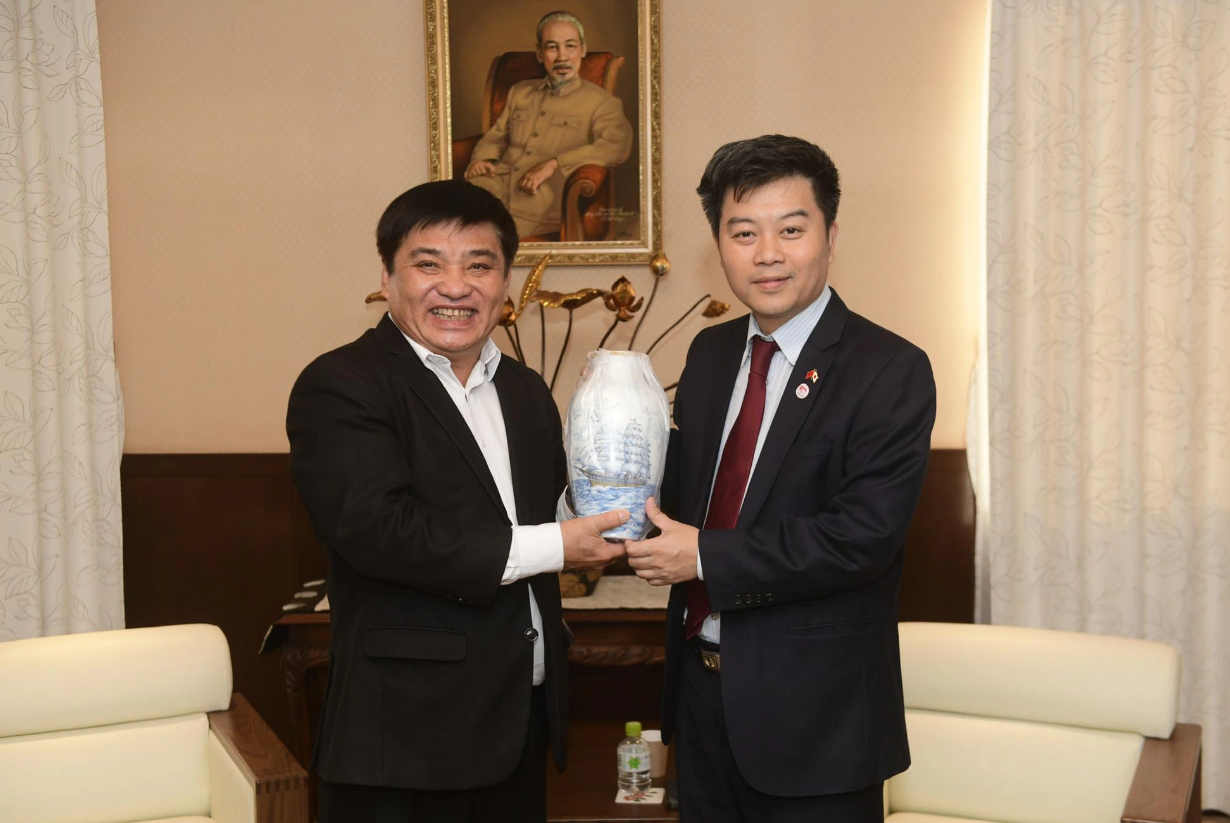 Tuoi Tre's Editor-in-Chief Le The Chu (L) gives a gift to Nguyen Duc Minh, chargé d'affaires of the Vietnamese Embassy in Japan. Photo: Quang Dinh / Tuoi Tre