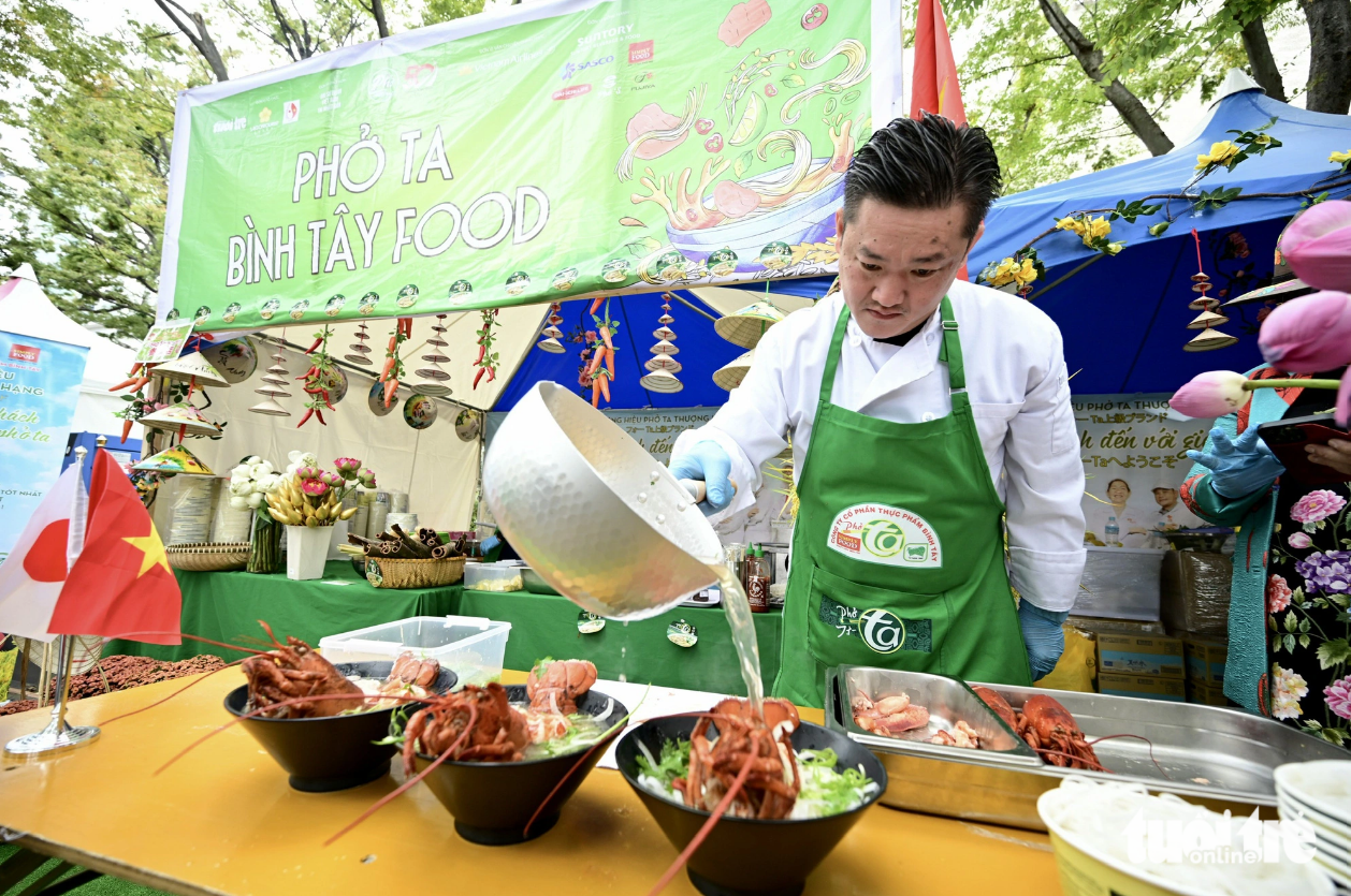 Chef Khai Vu cooks lobster pho at the Pho Ta - Binh Tay stall during the Vietnam Phở Festival 2023 at Yoyogi Park, Tokyo on October 8, 2023. Photo: Tuoi Tre
