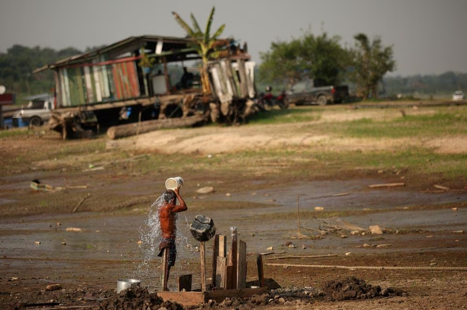 Fisherman Raimundo da Silva do Carmo, 67, baths with water from a well on Puraquequara Lake, which has been affected by drought, in Manaus, Brazil, October 6, 2023. Photo: Reuters
