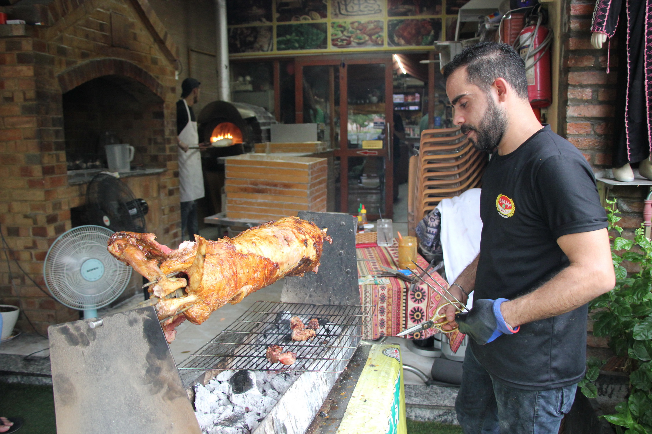 Staff grill a lamb in front of Al-Sham Saigon. Photo: Dong Nguyen / Tuoi Tre News