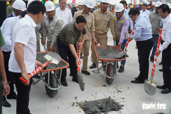 Prime Minister Pham Minh Chinh and other delegates make a symbolic gesture to connect the last sections of the My Thuan 2 Bridge. Photo: Mau Truong / Tuoi Tre